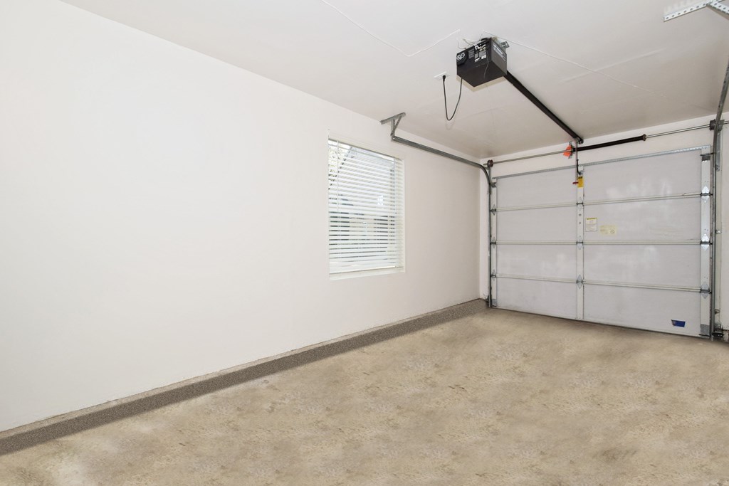 an empty room with a garage door and a window